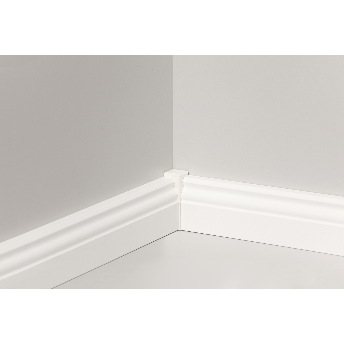 Ecke eines Raumes mit weißer Sockelleiste an zwei Wänden und dem Boden