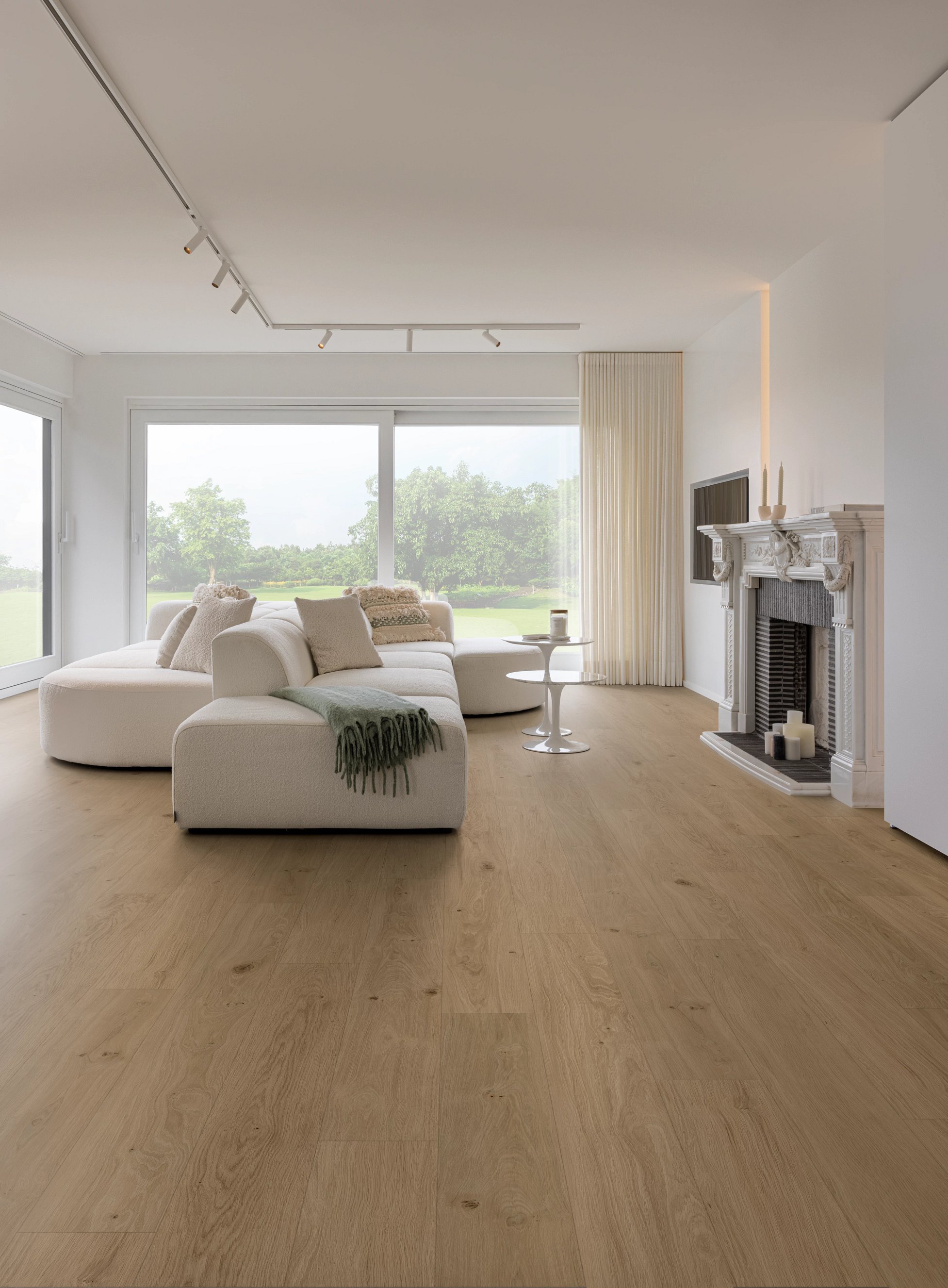 Stilvolles Wohnzimmer mit heller Sofalandschaft, großem Fenster und Holzfußboden